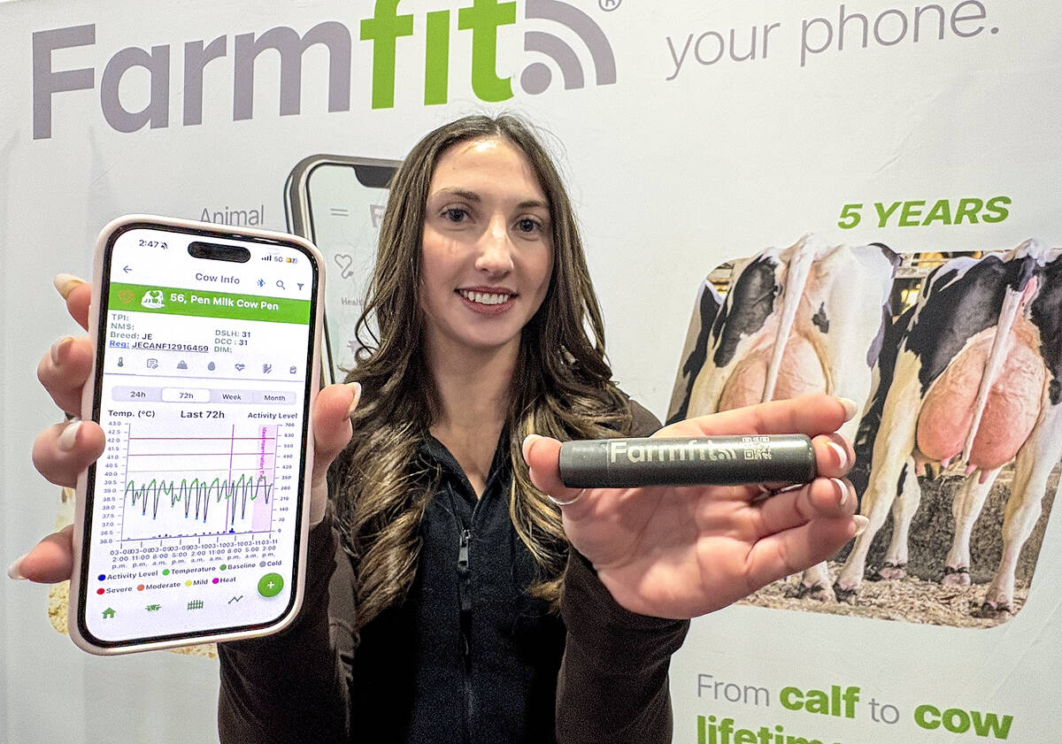 Brooklyn Lloyd, an STgenetics FarmFit technical specialist and early adopter of the technology on her family’s jersey dairy, demonstrates the bolus size and the app’s information display during the Ottawa Valley Farm Show in March 2026.  Photo: Diana Martin